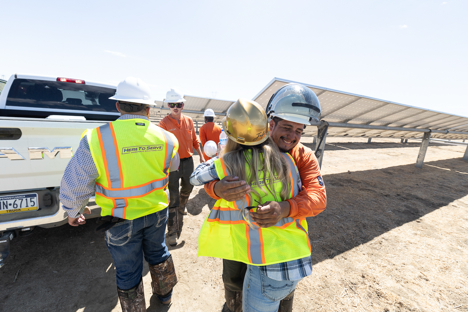 HTS Renewables crew members embracing on a solar job site — the culture that defines us